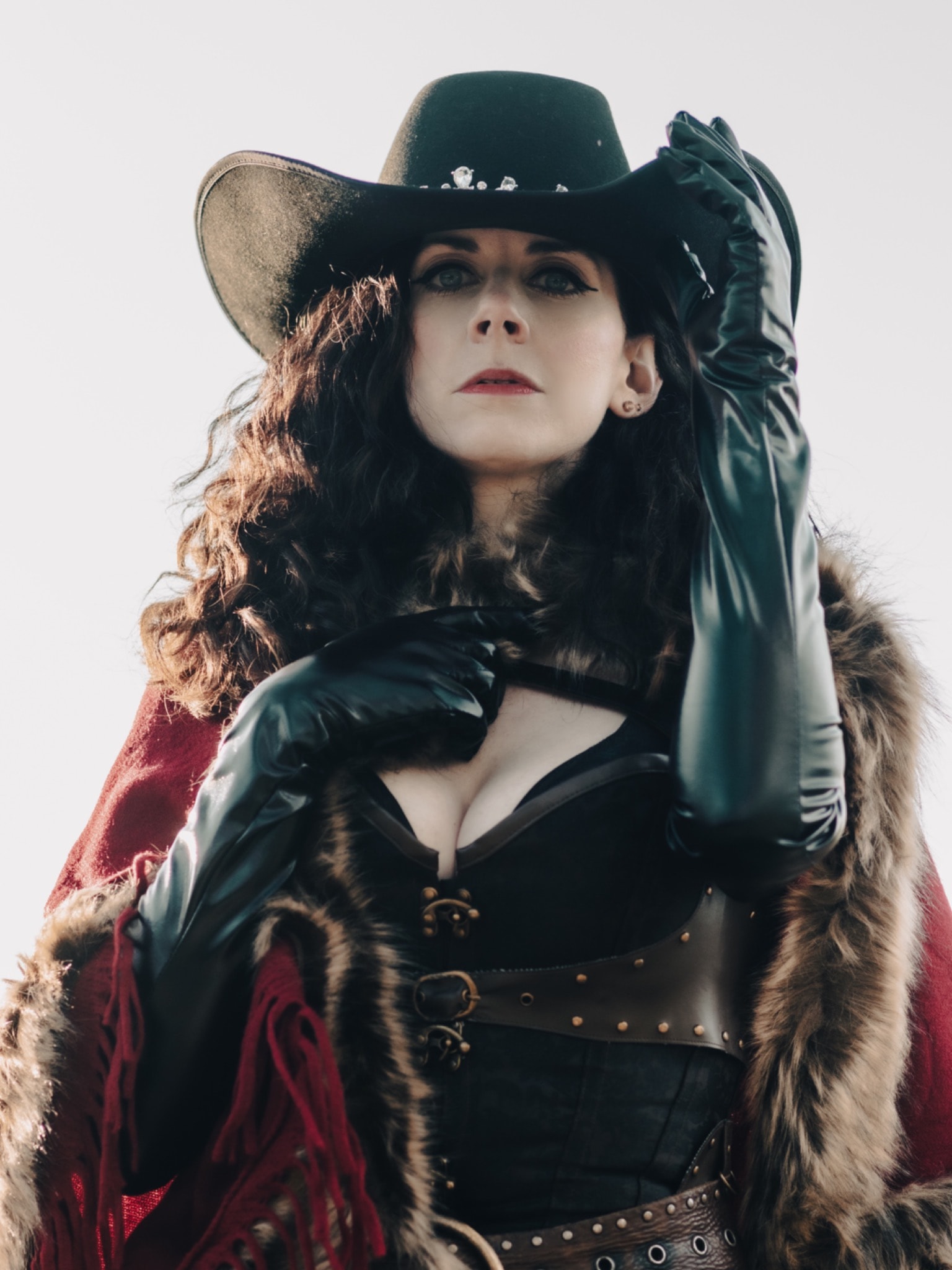 Melissa Endean in black cowboy hat and leather gloves, dramatic portrait
